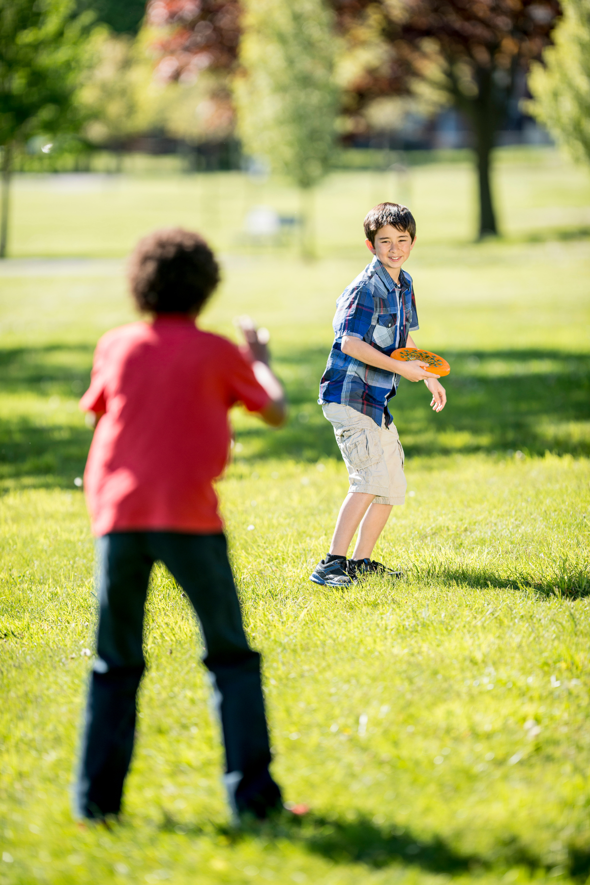 Boys playing frisbee at park