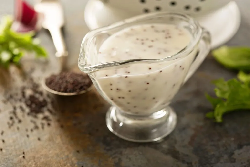 closeup of poppy seed dressing in glass pourer