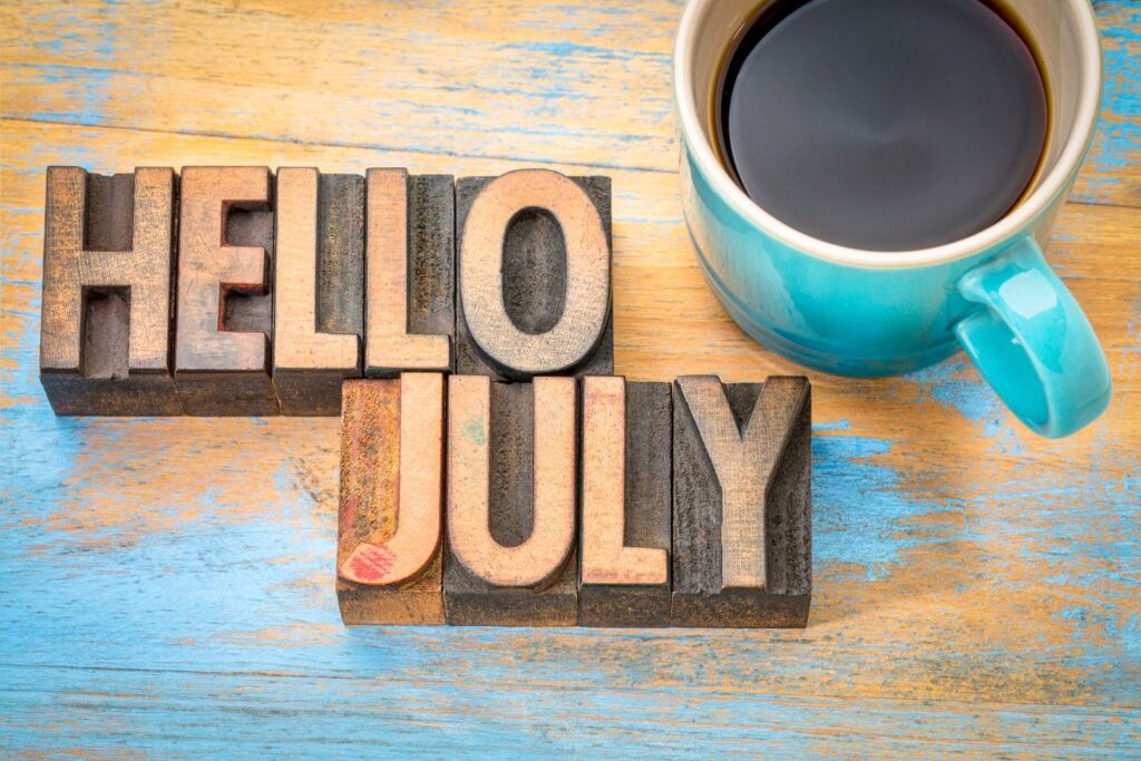 Hello July wood blocks with cup of coffee on wooden desk