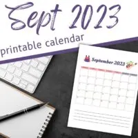 Printed September calendar with notepad and pen on dark desktop