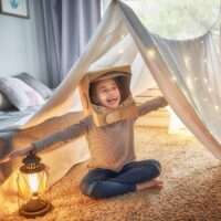 happy kid playing inside a tent