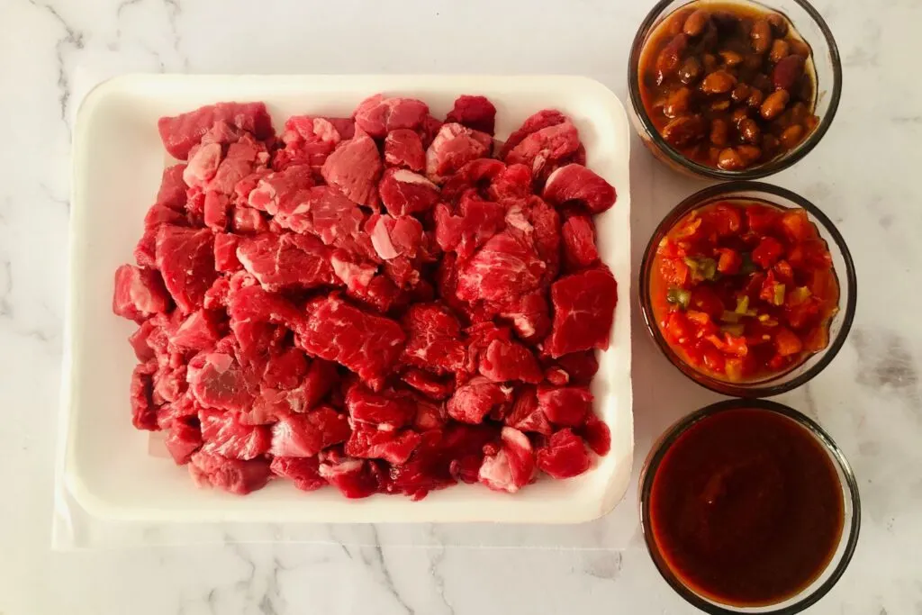 ingredients for stew meat chili - beef, beans, tomatoes and chipotle sauce