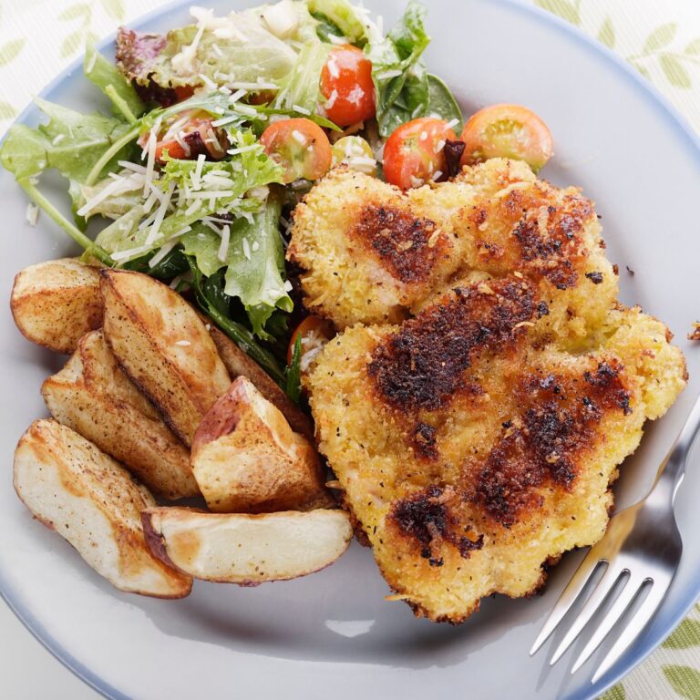Parmesan chicken with potato wedges and green salad