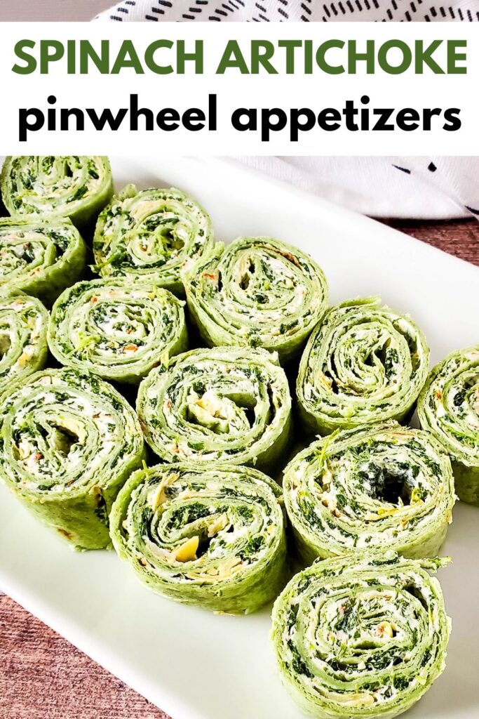 spinach and artichoke pinwheels appetizers on white rectangle serving platter