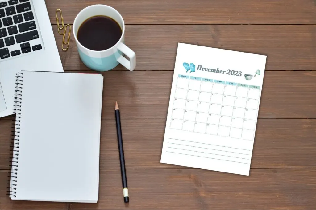 November printable calendar on desk with notepad coffee and laptop