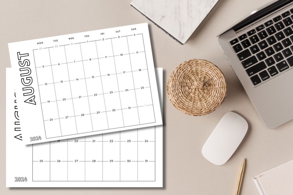 August 2024 calendars on tan desktop with laptop and mouse