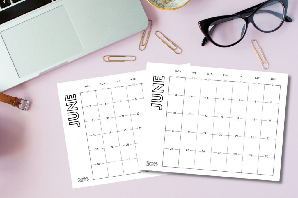 printed June calendars on pink desktop with laptop and glasses